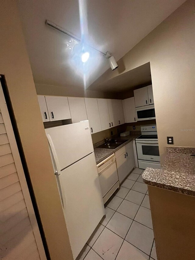 kitchen featuring sink, light tile patterned floors, white appliances, and white cabinetry