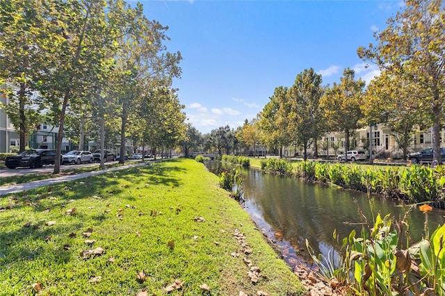 surrounding community featuring a lawn and a water view