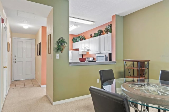 carpeted dining space featuring a textured ceiling