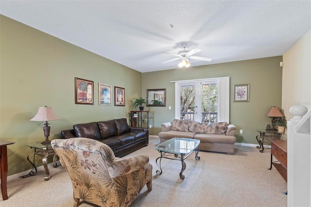 living room with ceiling fan, a textured ceiling, and light carpet