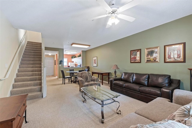 carpeted living room with ceiling fan