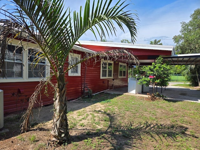 view of side of home featuring washer / clothes dryer and a carport