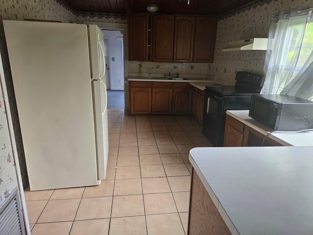 kitchen with light tile patterned flooring, sink, white fridge, backsplash, and black / electric stove