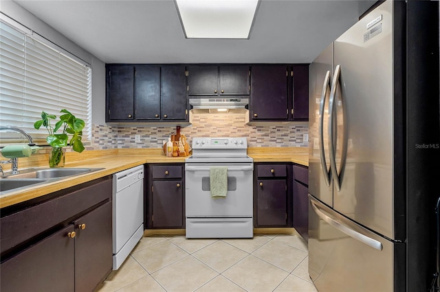 kitchen with sink, light tile patterned floors, white appliances, butcher block countertops, and backsplash