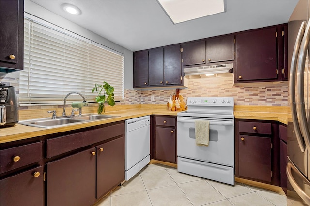 kitchen featuring white appliances, light tile patterned flooring, sink, and tasteful backsplash