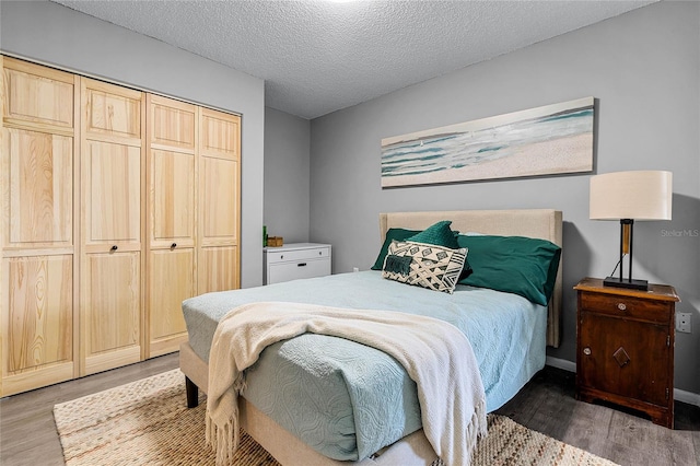 bedroom featuring a textured ceiling, a closet, and dark wood-type flooring