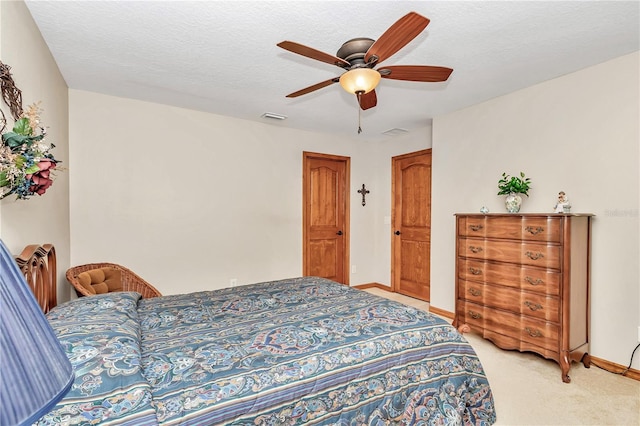 carpeted bedroom featuring a textured ceiling and ceiling fan