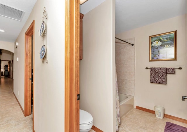 bathroom with tile patterned floors, tiled shower / bath, and toilet