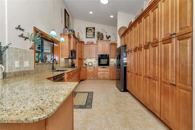 kitchen with kitchen peninsula, tasteful backsplash, light stone counters, sink, and black appliances