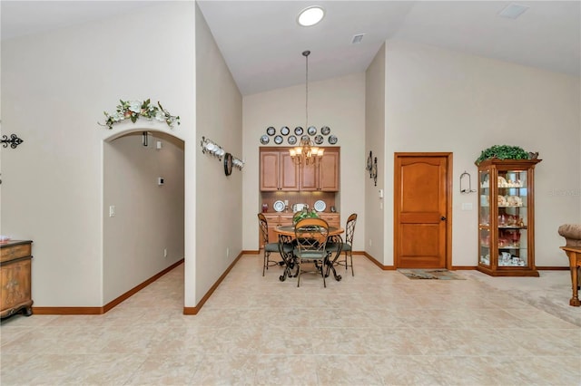 dining room with high vaulted ceiling and a notable chandelier