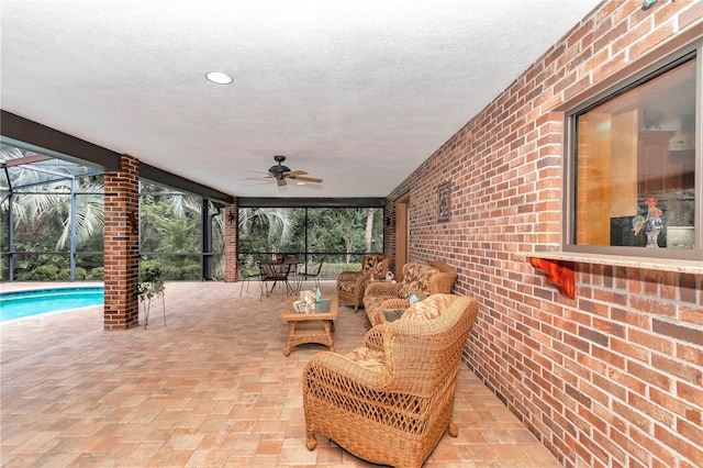 view of patio / terrace with an outdoor hangout area, glass enclosure, and ceiling fan