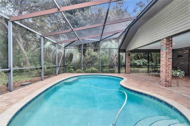 view of swimming pool with glass enclosure and a patio