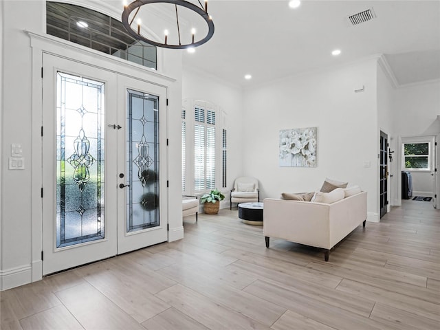 foyer entrance with light hardwood / wood-style floors, plenty of natural light, and french doors