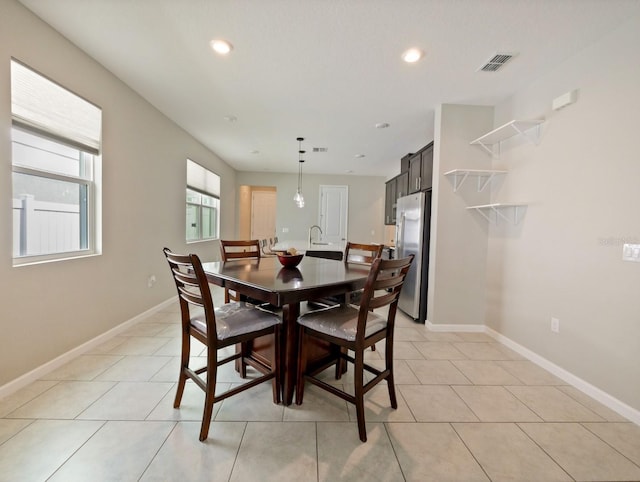 dining room featuring sink and light tile patterned floors