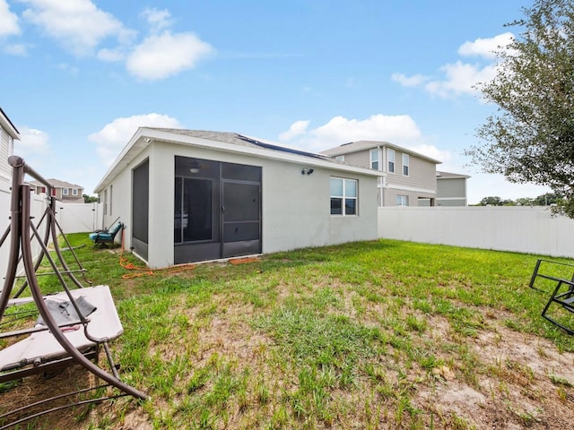 back of property featuring a sunroom and a yard