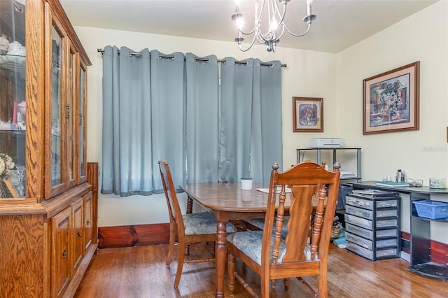 dining area featuring an inviting chandelier and dark wood-type flooring