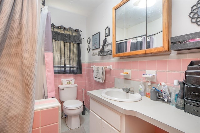 bathroom with tile walls, a shower with curtain, vanity, and toilet