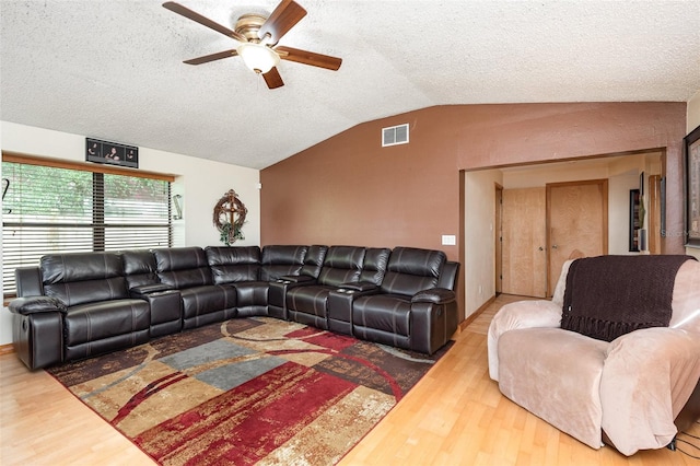 living room featuring hardwood / wood-style flooring, ceiling fan, a textured ceiling, and lofted ceiling