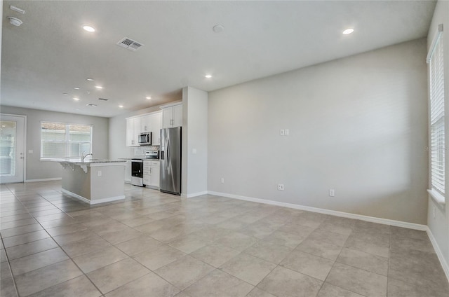 unfurnished living room with light tile patterned floors and sink