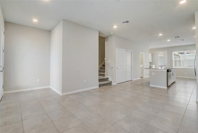 unfurnished living room with light tile patterned flooring and sink