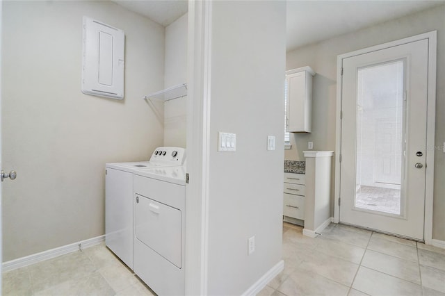 clothes washing area featuring light tile patterned floors, electric panel, and washer and dryer