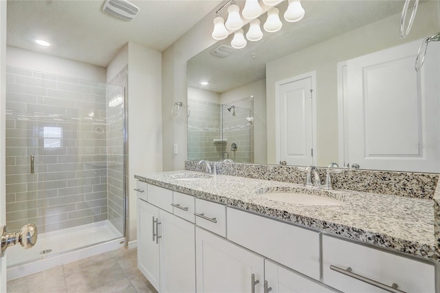 bathroom featuring vanity, a shower with shower door, and tile patterned flooring