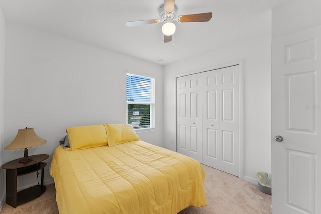 carpeted bedroom featuring ceiling fan and a closet