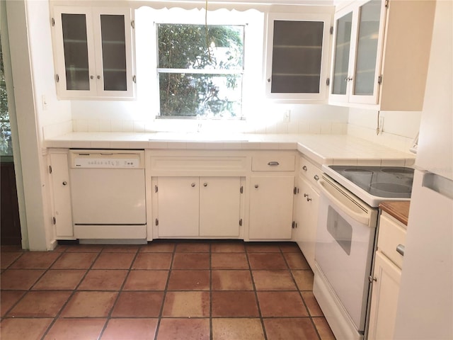 kitchen featuring white cabinets, sink, white appliances, tasteful backsplash, and tile countertops