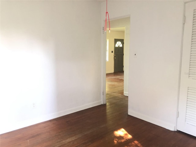 unfurnished room with dark hardwood / wood-style flooring