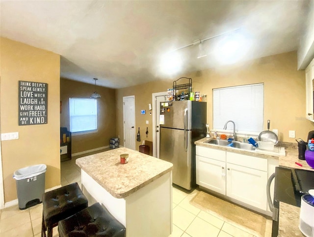 kitchen featuring white cabinets, stainless steel fridge, hanging light fixtures, and light tile patterned flooring