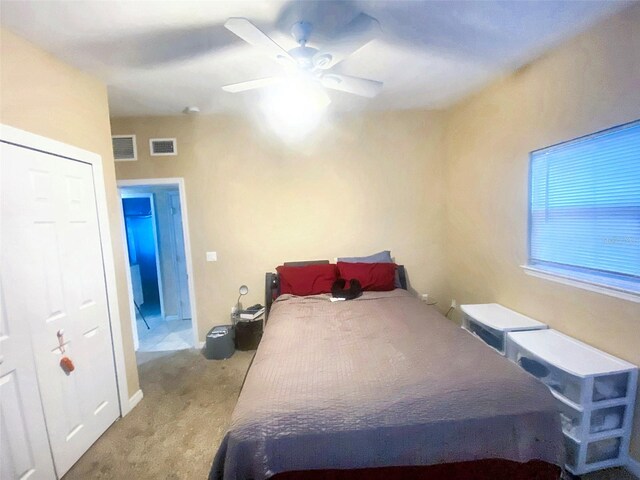 bedroom featuring ceiling fan, a closet, and light carpet