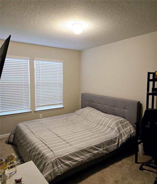 bedroom with a textured ceiling and carpet floors