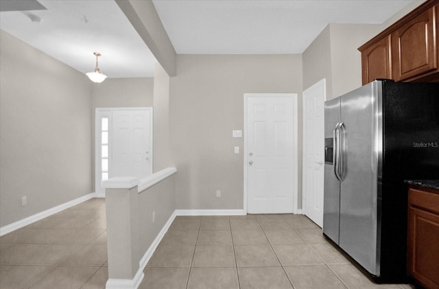 kitchen featuring light tile patterned floors, stainless steel fridge with ice dispenser, and decorative light fixtures