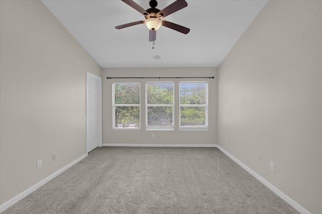 carpeted empty room with vaulted ceiling and ceiling fan