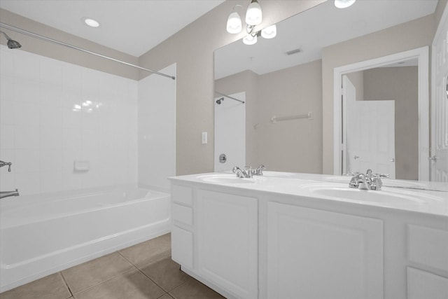 bathroom with tile patterned flooring, vanity, and tiled shower / bath