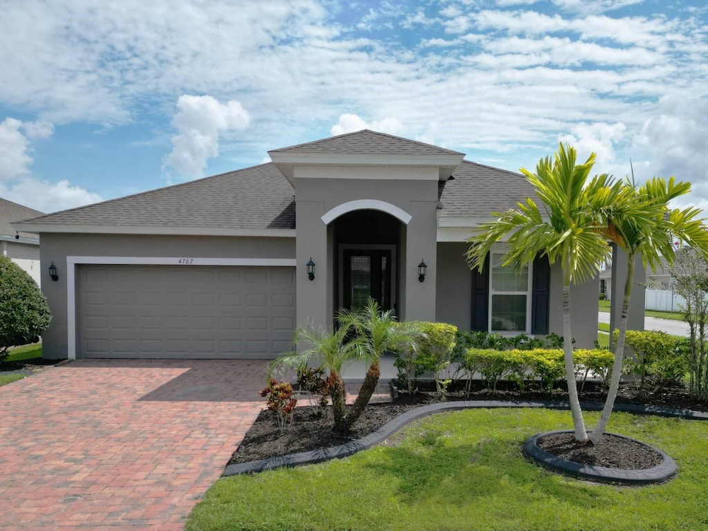 view of front of property featuring a front yard and a garage