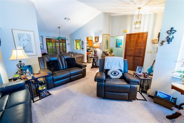 living room featuring light colored carpet, ceiling fan with notable chandelier, and vaulted ceiling