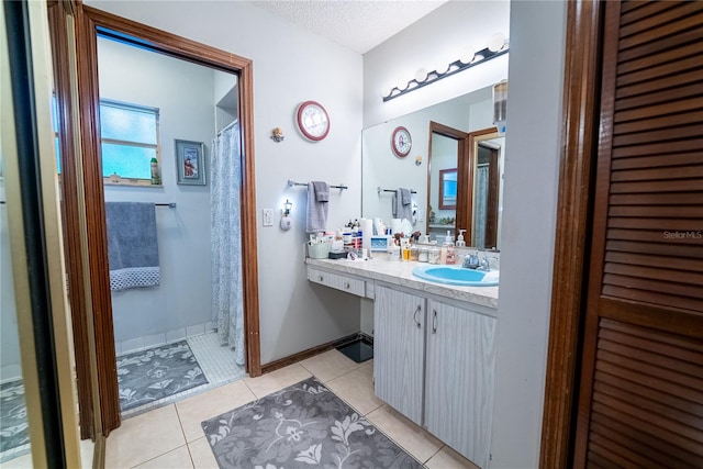 bathroom with tile patterned floors, a textured ceiling, and vanity