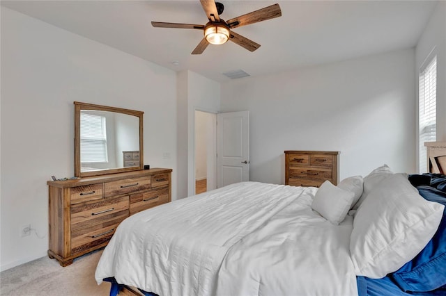 carpeted bedroom with ceiling fan and multiple windows