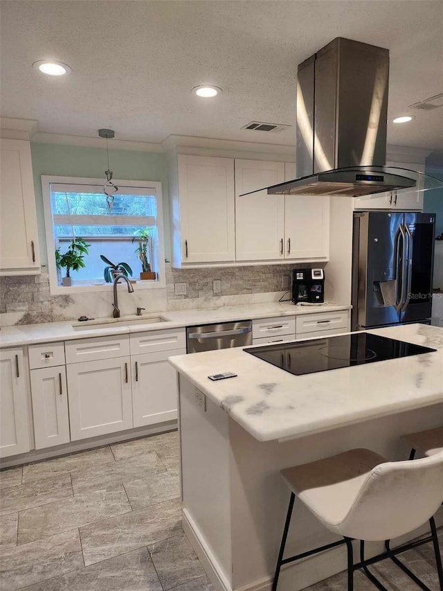 kitchen with white cabinetry, sink, decorative light fixtures, exhaust hood, and appliances with stainless steel finishes