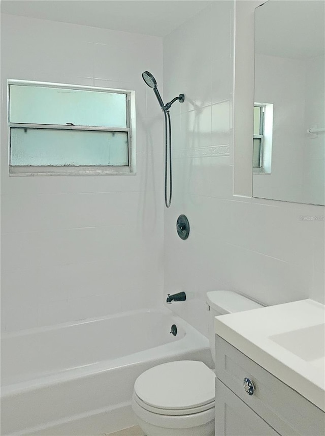 full bathroom with tiled shower / bath, vanity, and toilet