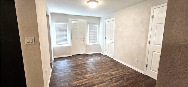 entryway with dark hardwood / wood-style floors and a textured ceiling