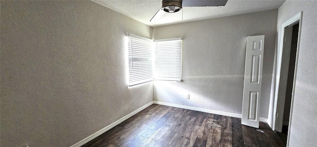 empty room with ceiling fan, dark hardwood / wood-style flooring, and a textured ceiling