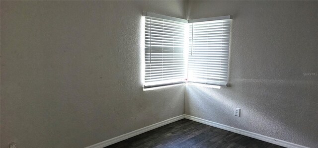 empty room with dark hardwood / wood-style flooring