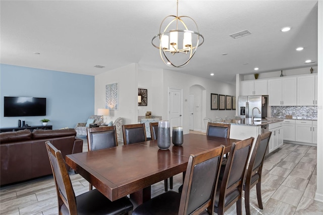 dining room with sink and a notable chandelier