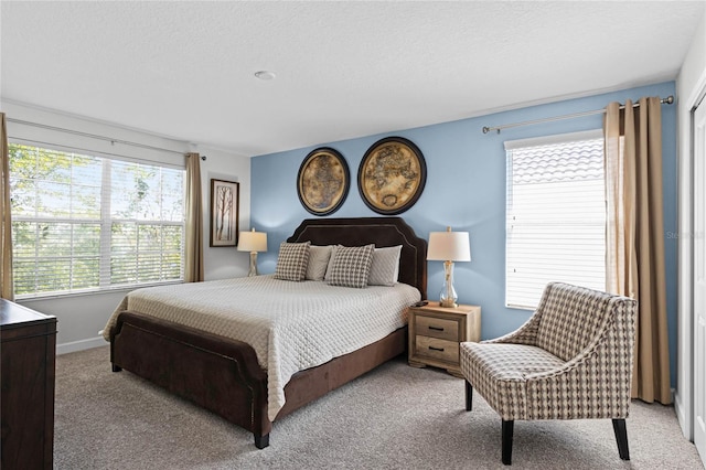 bedroom featuring light colored carpet and a textured ceiling