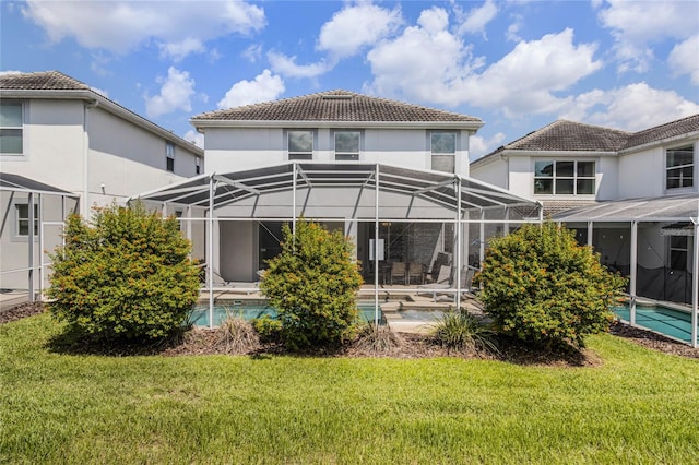 back of property featuring glass enclosure, a patio area, and a yard