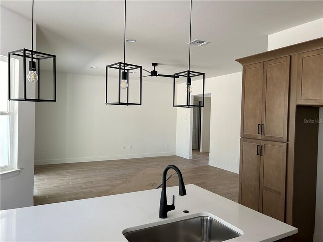 kitchen featuring dark hardwood / wood-style flooring, sink, and hanging light fixtures