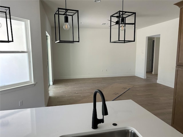 kitchen featuring sink, dark wood-type flooring, hanging light fixtures, and an inviting chandelier