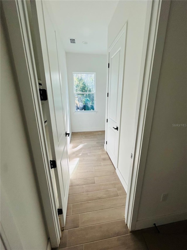 corridor with light hardwood / wood-style flooring